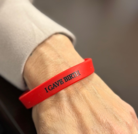 red bracelet with the words I gave birth